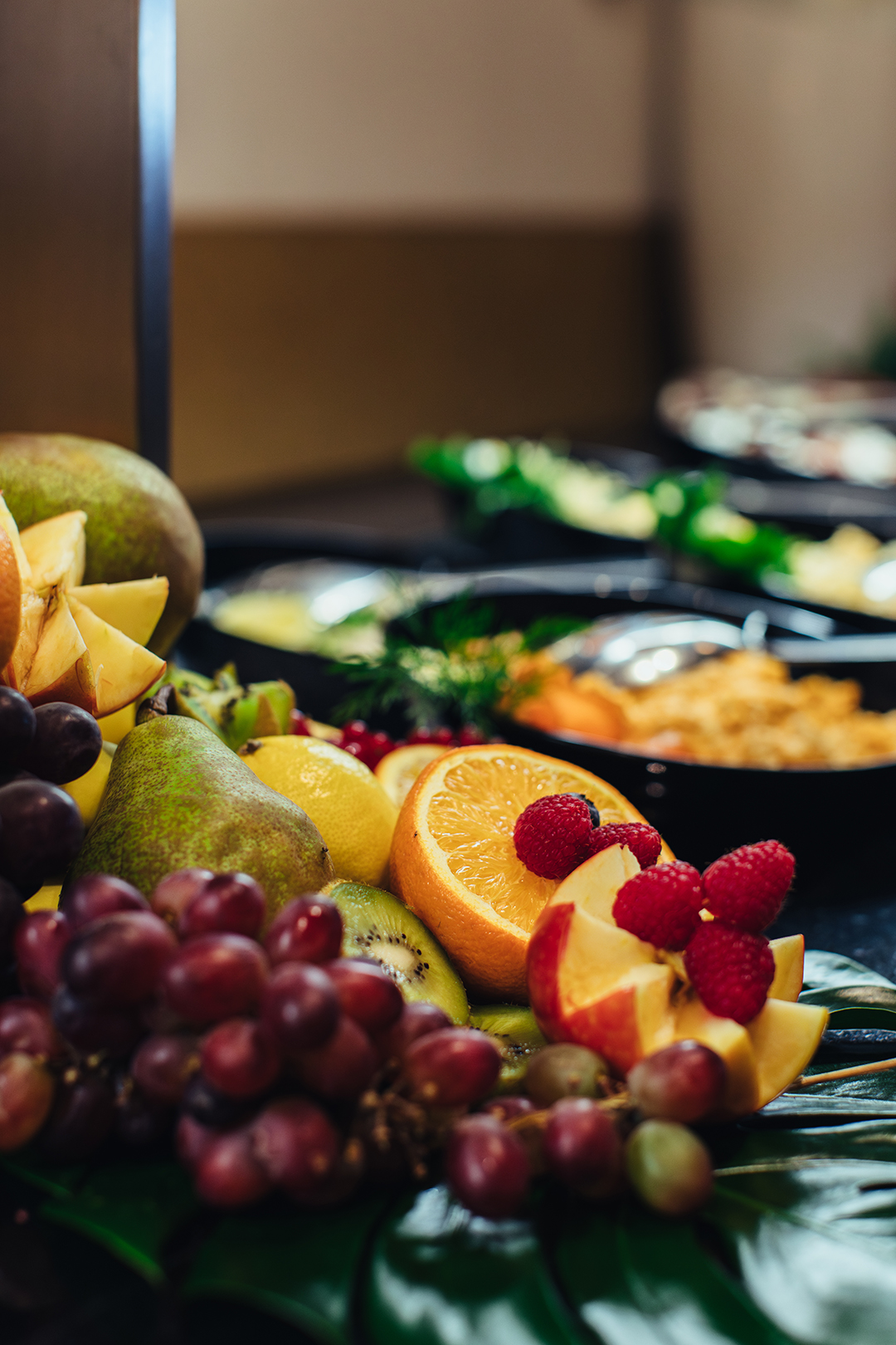 Vers fruit en kleurrijke citrusvruchten liggen uitnodigend uitgestald op het wereldse buffet van De Blaauwe Kamer in Wageningen, tussen internationale gerechten, warme geuren en de levendige sfeer van een restaurant waar smaken uit verschillende culturen samenkomen.