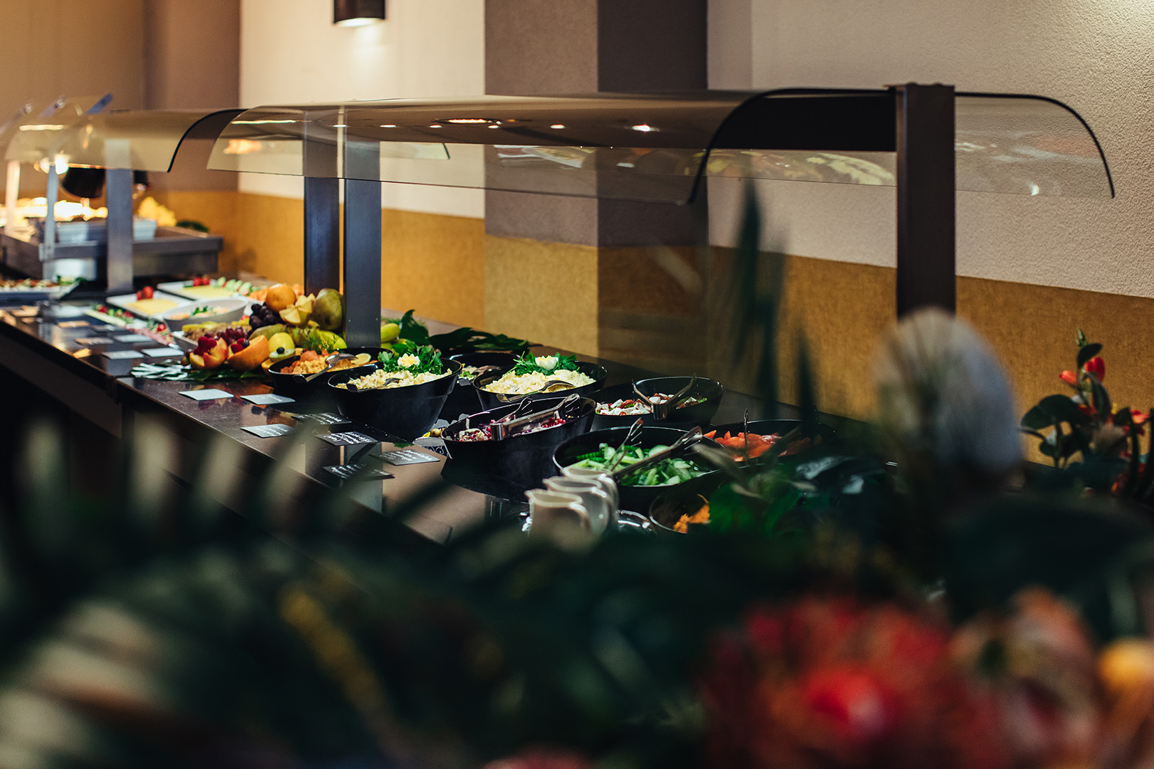 Het kleurrijke buffet van De Blaauwe Kamer in Wageningen gevuld met salades, groenten en wereldse gerechten, uitnodigend gepresenteerd onder warm licht in een sfeervol restaurant vol wereldse smaken.